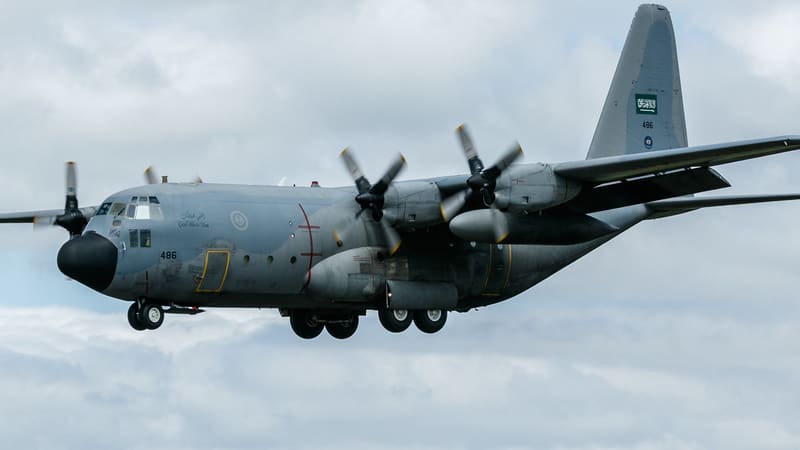 Royal Saudi Air Force C-130H Hercules transport aircraft with its landing gear down against a cloudy sky