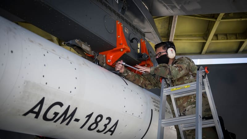AGM-183A hypersonic missile test round mounted under a B-52H wing as an airman secures it