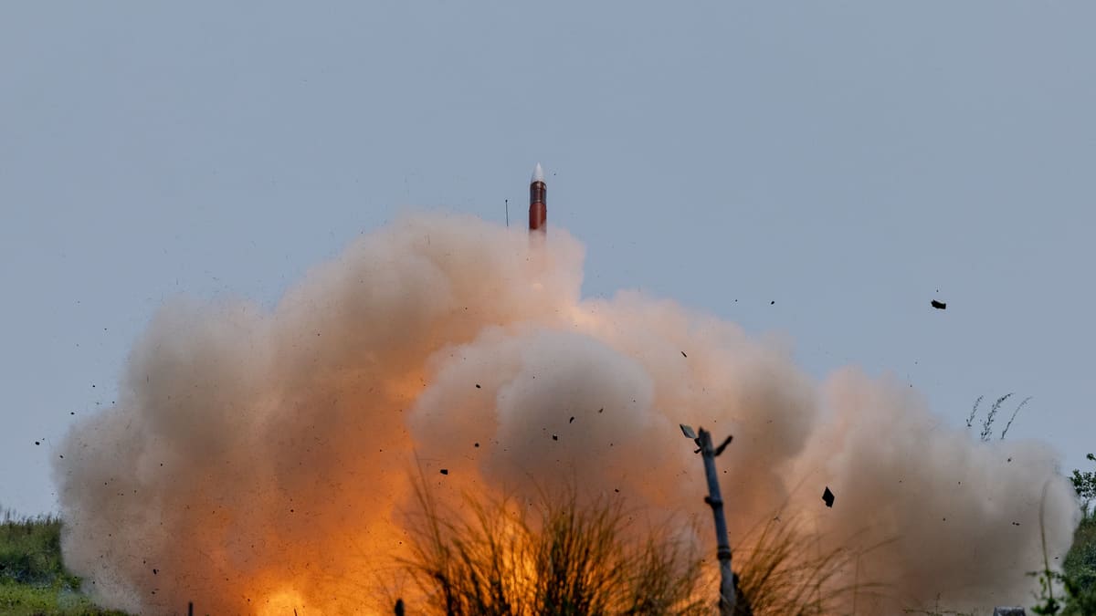 A Patriot interceptor climbs out of a fireball and dust cloud after launch during a live-fire exercise
