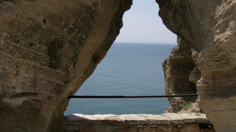 The Black Sea seen through a rock arch above a stone wall at Cape Kaliakra on Bulgaria's northern coast.