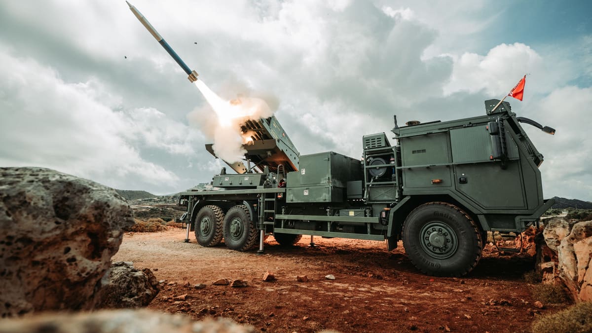 A Dutch PULS rocket launcher on a six-wheel truck fires a rocket from its pod on a rocky hillside on Crete