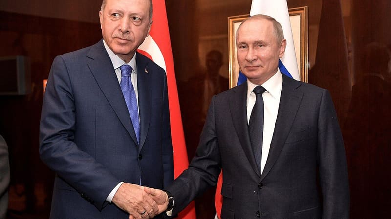 Presidents Erdoğan (left) and Putin shake hands in front of Turkish and Russian flags, 2020 file photo
