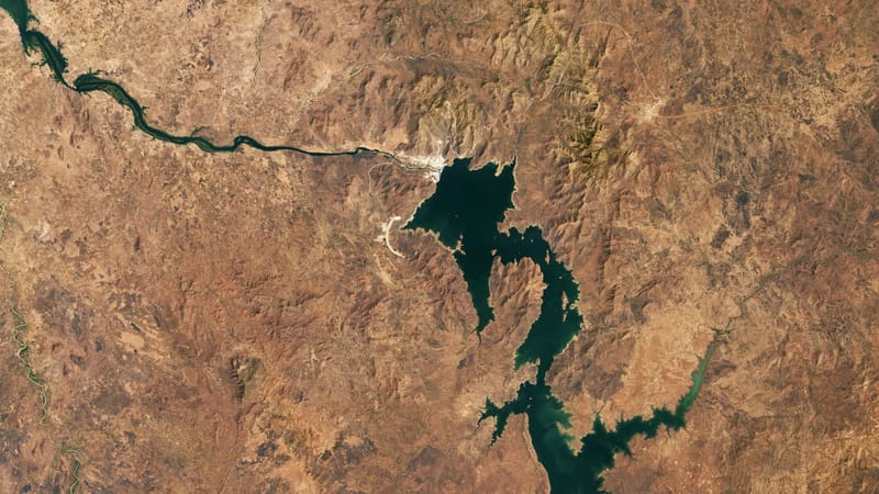 Satellite view of the Grand Ethiopian Renaissance Dam reservoir filling a winding Blue Nile valley in brown terrain