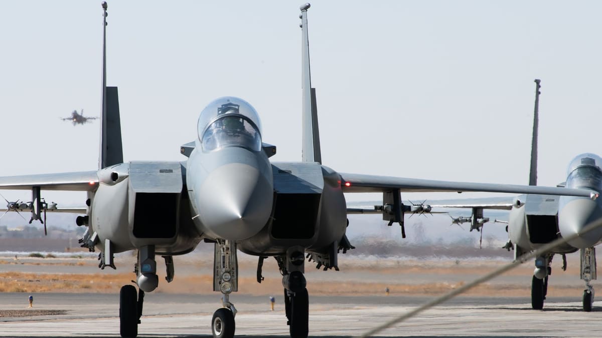 Two grey Royal Saudi Air Force F-15 fighter jets taxiing nose-on toward the camera on an air base apron