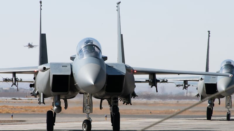 Two grey Royal Saudi Air Force F-15 fighter jets taxiing nose-on toward the camera on an air base apron