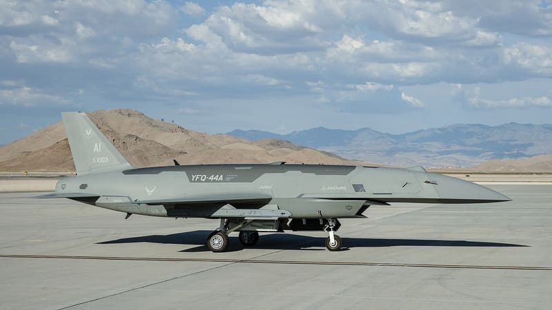 Grey Anduril YFQ-44A Fury drone parked on a concrete flightline with desert hills behind