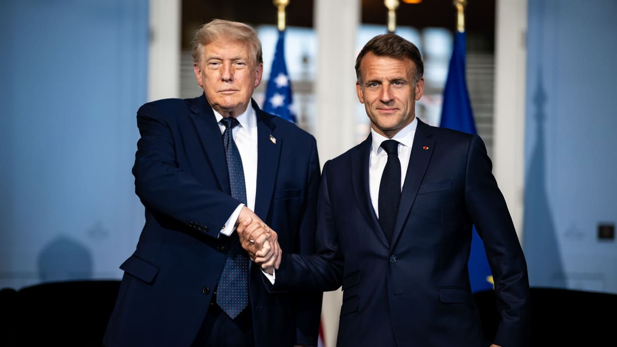 Donald Trump, left, and Emmanuel Macron shake hands in dark suits in front of US and European Union flags