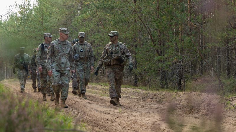 Maj. Gen. Brett Sylvia walks a forest track with 101st Airborne Division soldiers in Latvia