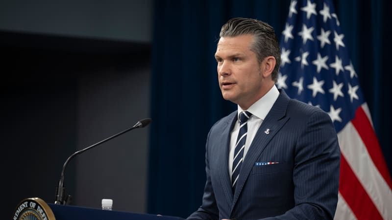 US Defense Secretary Pete Hegseth speaking at a lectern in the Pentagon briefing room, with a US flag behind him