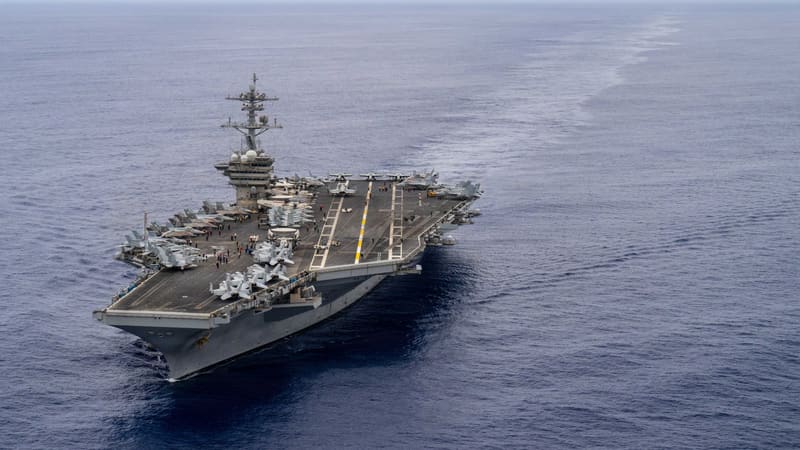 Aerial view of the US aircraft carrier USS Theodore Roosevelt under way at sea, with aircraft parked on its flight deck