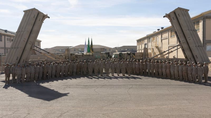 Rows of Saudi soldiers standing between two raised THAAD launchers, with three flags in the centre