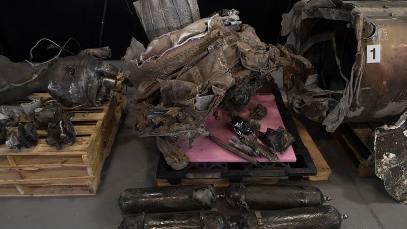 Crumpled airframe wreckage, pressure tanks and an engine section of recovered ballistic missiles laid out on pallets