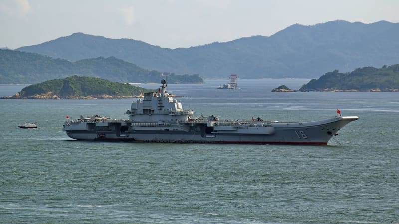 Chinese aircraft carrier Liaoning, hull number 16, at anchor off Hong Kong with fighter jets and helicopters on deck