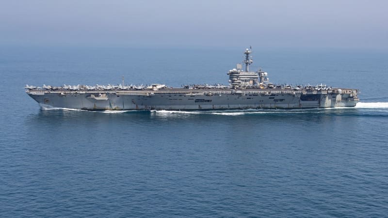 Aircraft carrier USS George Washington sailing in hazy weather, seen from the side, with aircraft lined up on deck