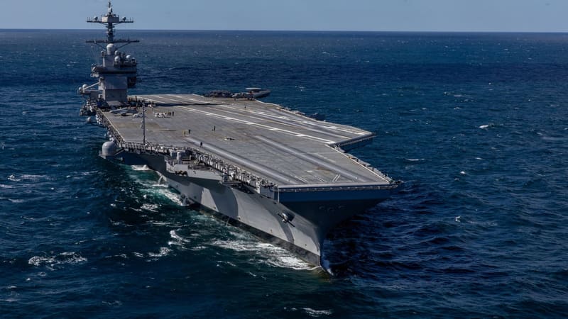 Future aircraft carrier USS John F. Kennedy under way, seen from above and ahead of the bow, with a mostly empty flight deck