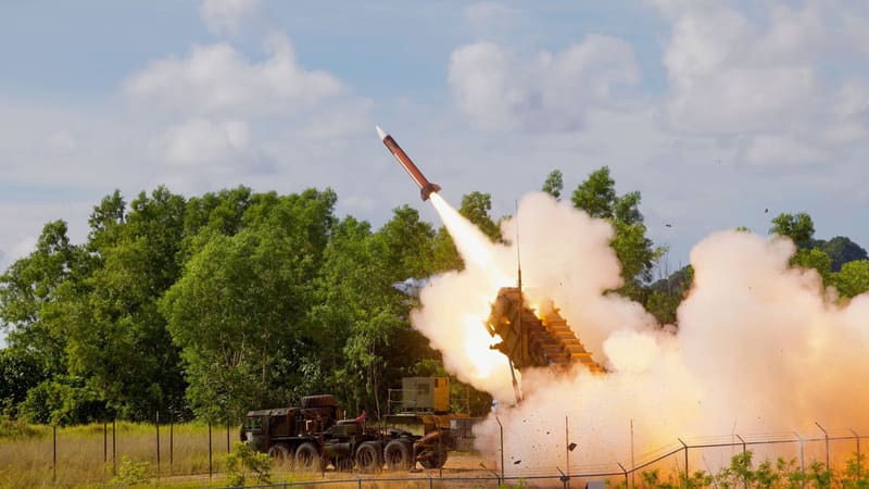 A Patriot PAC-2 interceptor rises from a tilted M903 launcher hitched to an Army truck, in a cloud of exhaust in Palau