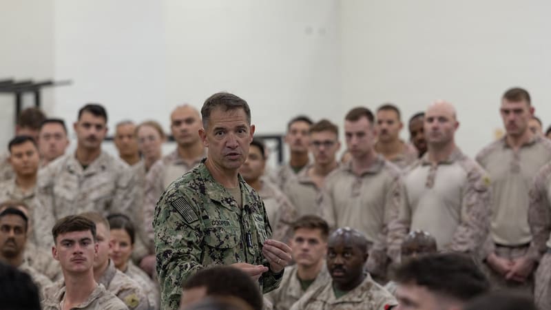 Adm. Brad Cooper in Navy camouflage speaking to a crowd of US Marines
