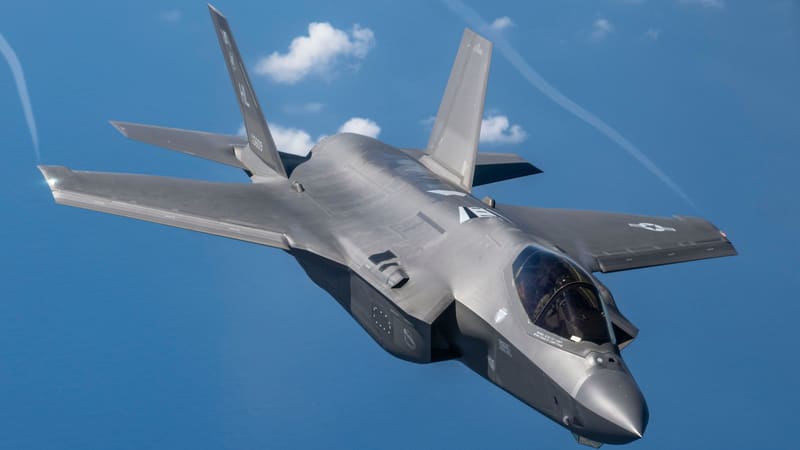 A gray U.S. Air Force F-35A stealth fighter banks over the blue Pacific Ocean
