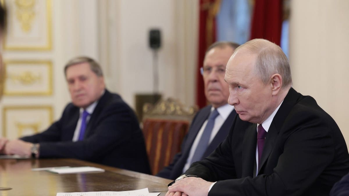 Vladimir Putin at a meeting table with two men seated behind him; Iran's foreign minister is not pictured
