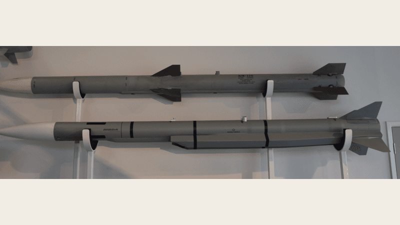 An MBDA Meteor air-to-air missile displayed beneath a Raytheon AIM-120 AMRAAM on a museum wall