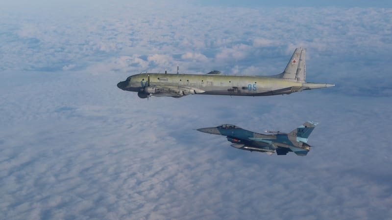 A U.S. Air Force F-16 flying alongside a Russian Il-38 patrol aircraft above clouds