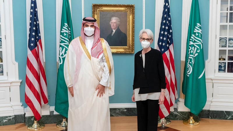 Prince Khalid bin Salman and Wendy Sherman, masked, stand between US and Saudi flags at the State Department, 2022
