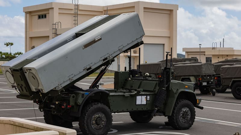 A U.S. Marine Corps NMESIS launcher with two missile canisters raised on a car park at a Japanese military camp