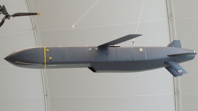 A grey Storm Shadow cruise missile with folded wings hanging from the ceiling of a museum hall