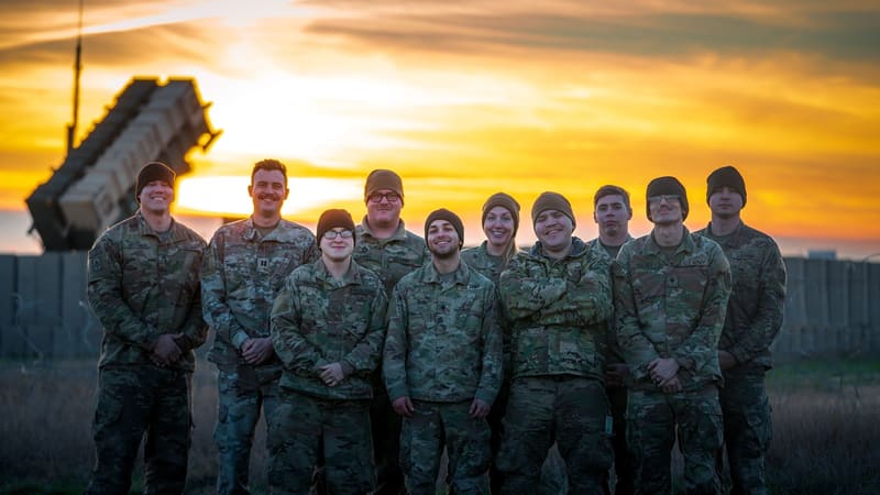 U.S. Army air defence soldiers pose at sunset in front of a Patriot missile launcher in Poland