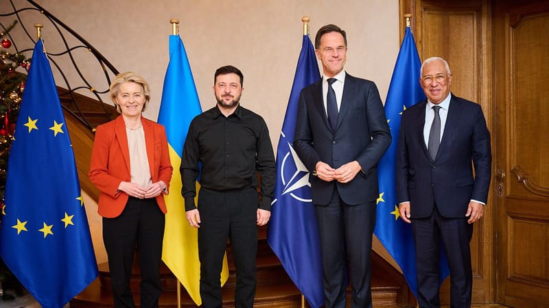Ursula von der Leyen, Volodymyr Zelensky, Mark Rutte and Antonio Costa stand before EU, Ukrainian and NATO flags