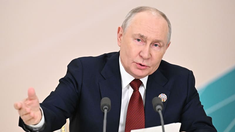 Vladimir Putin speaks at microphones, gesturing, at the Russia-Africa summit press conference