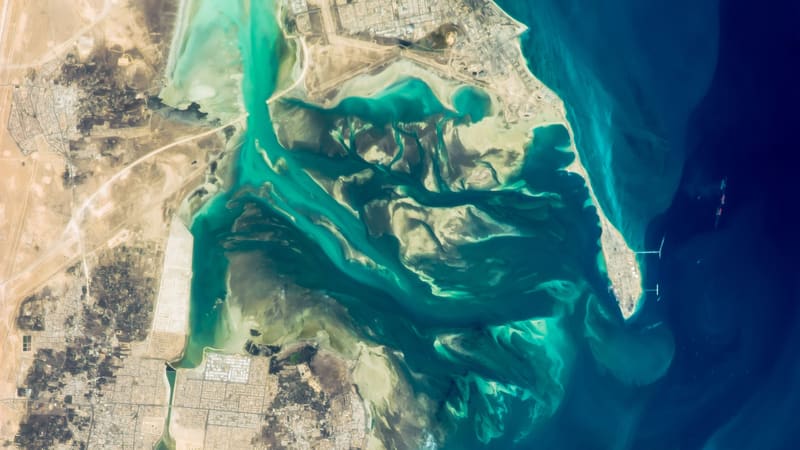 Astronaut photo of the Ras Tanura peninsula, with storage tanks and oil export piers at its tip, on Saudi Arabia's Gulf coast