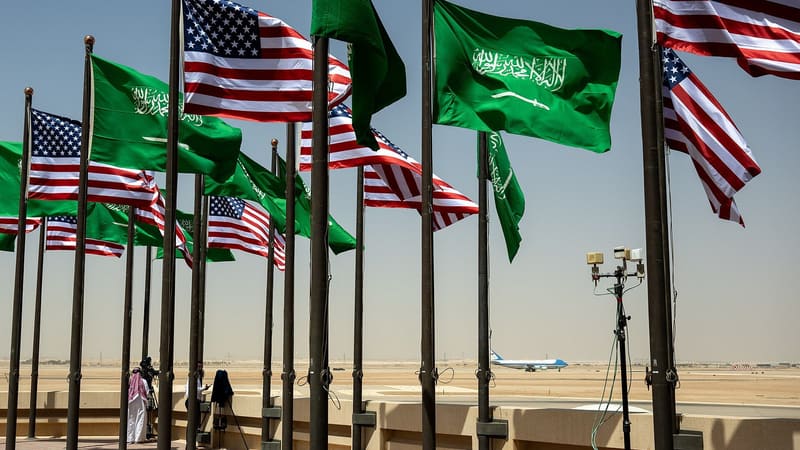 Saudi and US flags at Riyadh's King Khalid International Airport, a large Saudi flag in front, Air Force One on the runway
