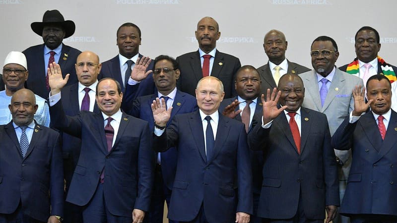 Vladimir Putin waving among African heads of delegation posing for a group photo