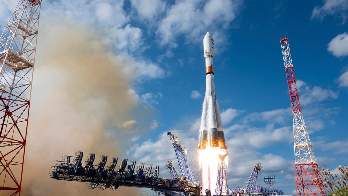 A Soyuz-2.1b rocket lifts off from a launch pad at Russia's Plesetsk Cosmodrome under a cloudy blue sky