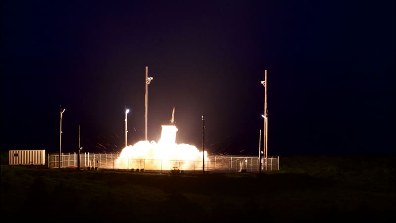 A THAAD interceptor rises from its launcher in a burst of light at night at a fenced test site in Kodiak, Alaska
