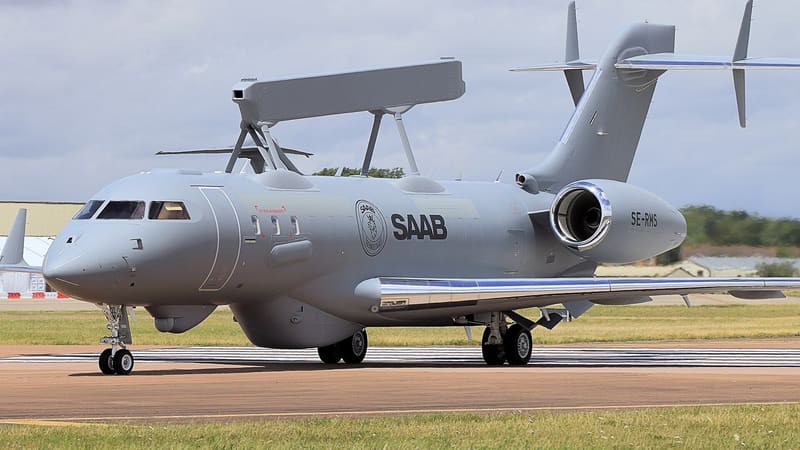 Grey Saab GlobalEye jet with a long box-shaped radar on its back taxiing at an airfield, registration SE-RMS