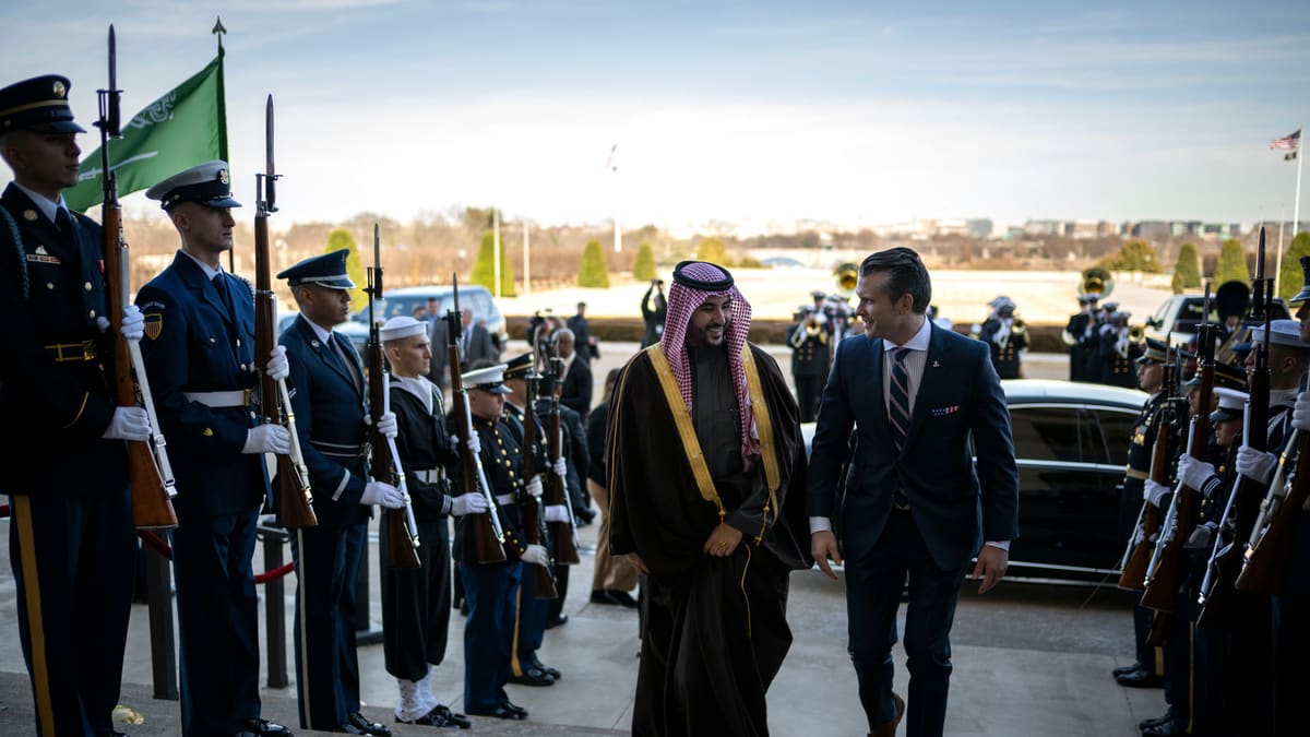 Saudi Prince Khalid bin Salman in a gold-trimmed robe walks with Pete Hegseth past an honour guard at the Pentagon