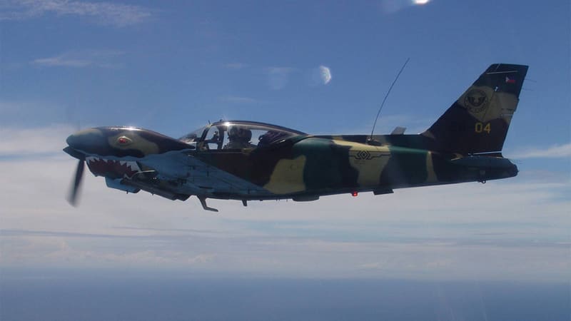 Camouflaged Philippine Air Force SF-260 with shark-mouth nose art flying over the sea