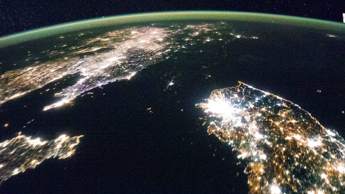 Night view from space of the Korean Peninsula, with a brightly lit South Korea and an almost dark North Korea