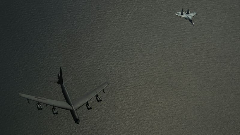 A Russian Su-27 fighter flies near a U.S. Air Force B-52H bomber over the dark waters of the Baltic Sea