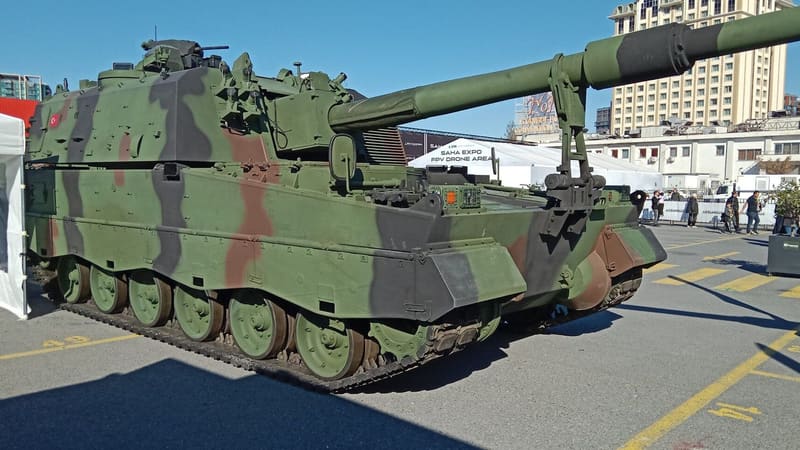 Camouflaged Turkish T-155 Fırtına tracked self-propelled howitzer parked outdoors at a defence exhibition
