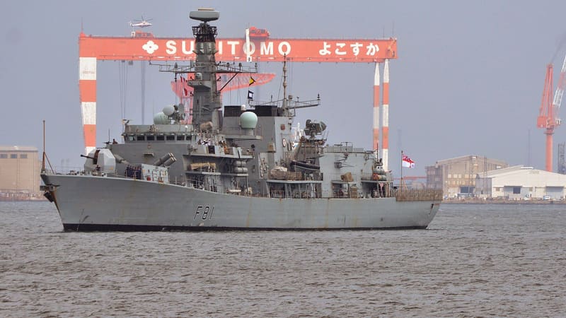 Grey Type 23 frigate HMS Sutherland arriving in harbour at Yokosuka with crew lining the deck