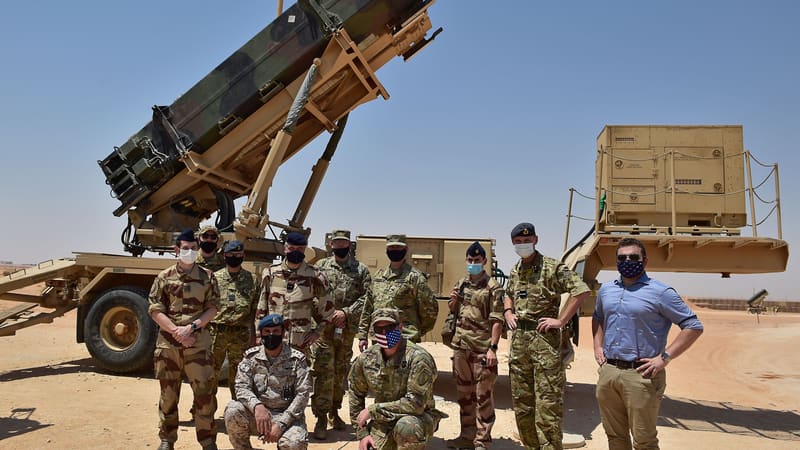 Patriot missile launcher at a Saudi desert air base with masked British, French, Saudi and US personnel posing in front