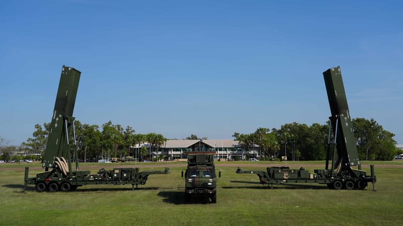 Two U.S. Army Dark Eagle hypersonic missile launchers with canisters raised and a command truck between them