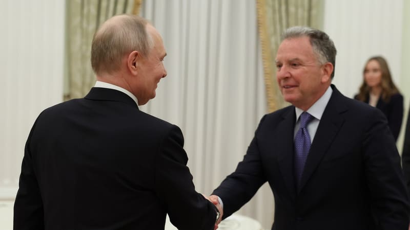 Vladimir Putin, seen from behind, shakes hands with Steve Witkoff in a formal reception room.