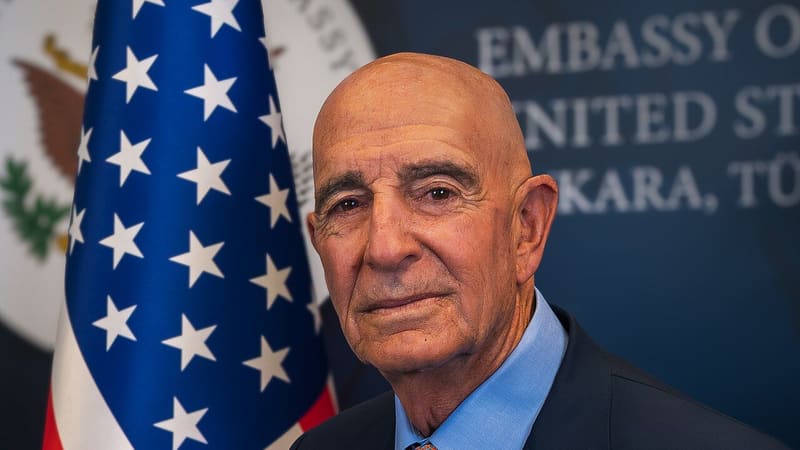 Portrait of Tom Barrack, US ambassador to Türkiye, in front of a US flag