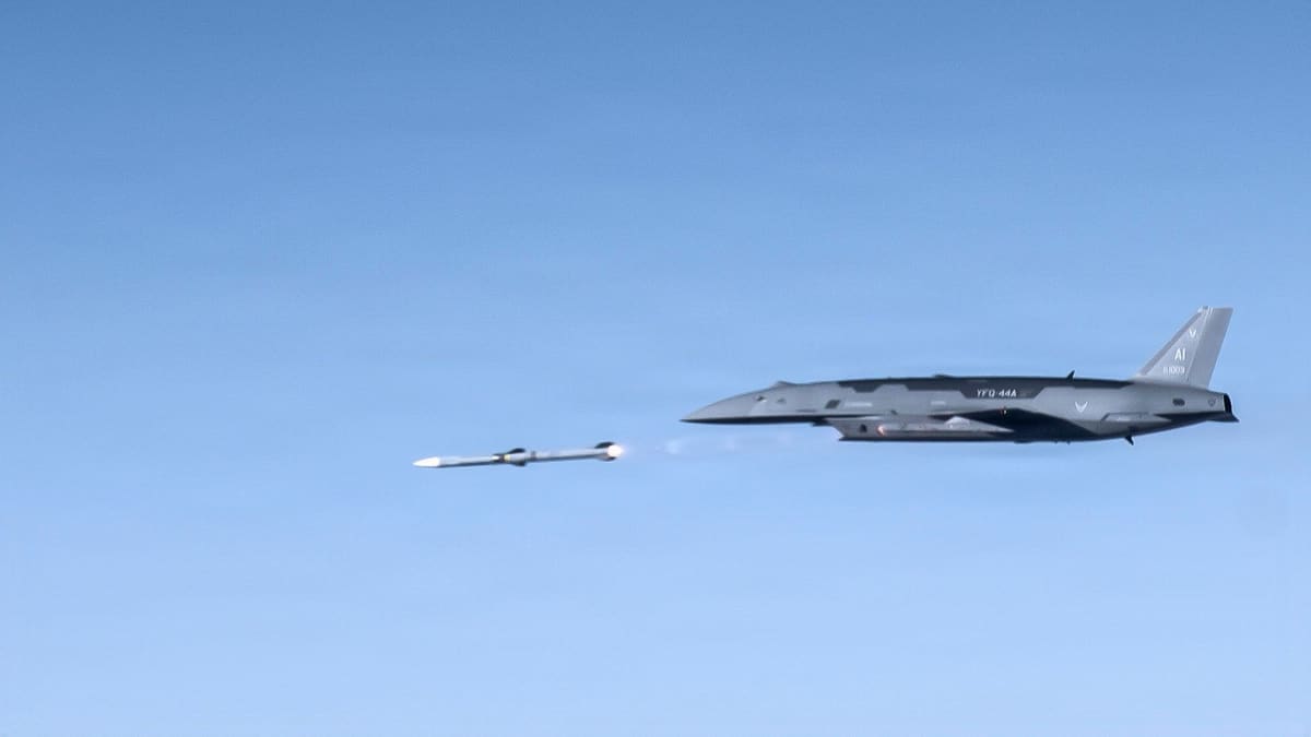 A YFQ-44A Fury drone launches an AIM-120 missile that streaks ahead of it against a clear blue sky
