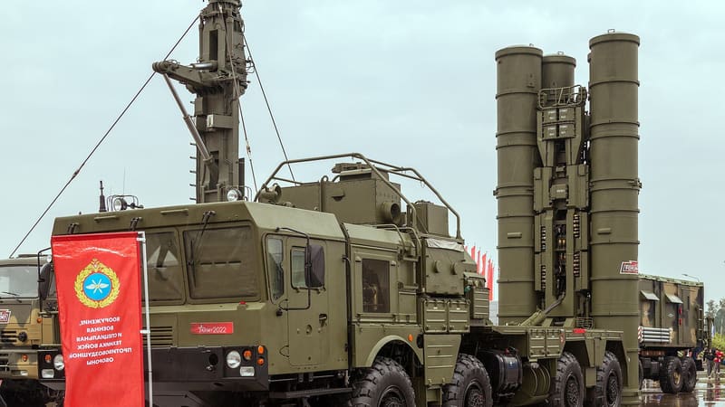 An S-400 Triumf launcher truck with its tall missile canisters raised upright at a military exhibition